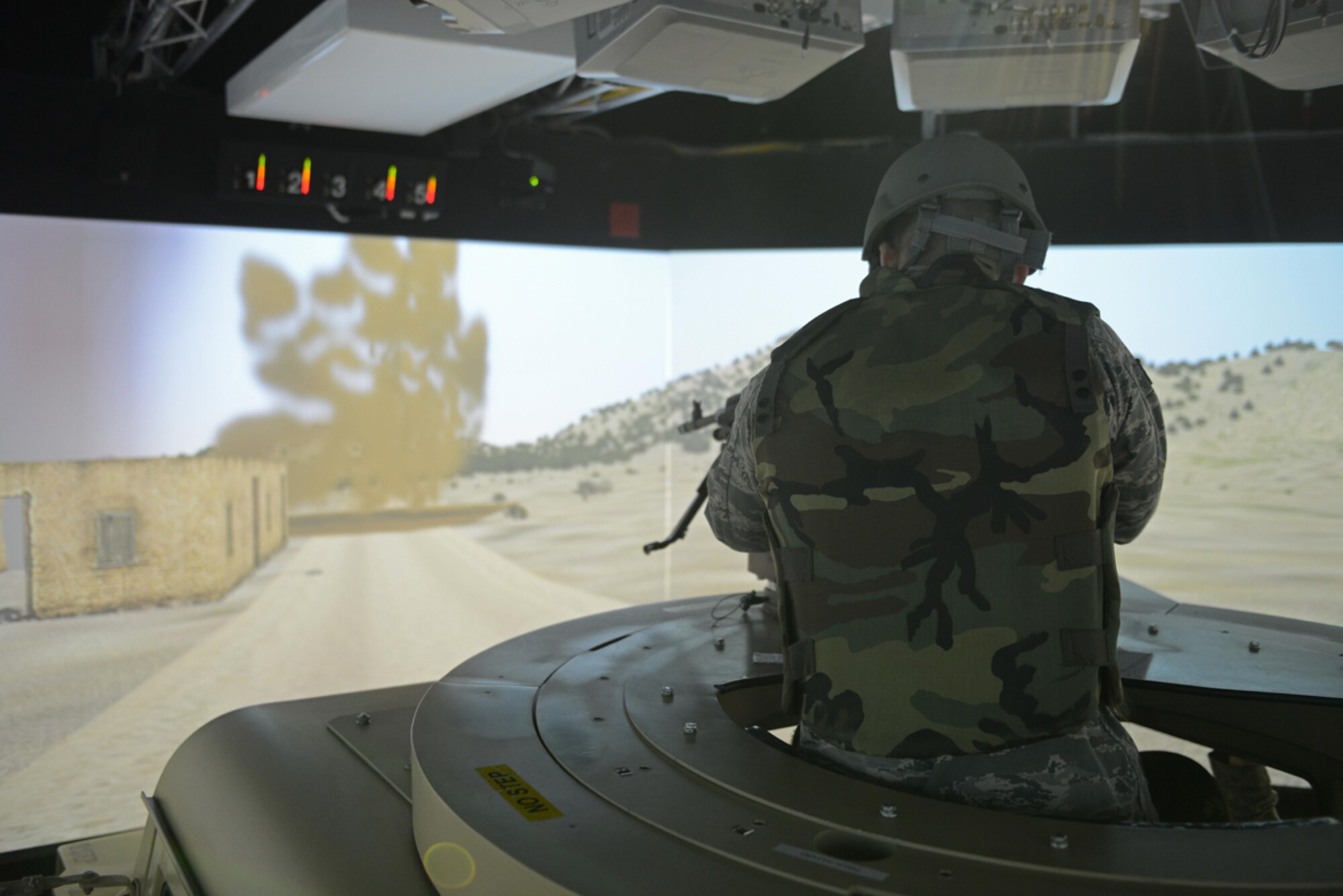 Senior Airman Jonathan Buenrostro, 673d Contracting Squadron contract specialist, operates a High Mobility Multipurpose Wheeled Vehicle mounted turret  during the Reconfigurable Vehicle Tactical Trainer program on Joint Base Elmendorf-Richardson, Alaska, June 18, 2014. Scenarios used during the simulator include route clearance and resupply delivery, where Soldiers transport supplies to forward operating bases while engaging enemies with suppressive fire. (U.S. Air Force photo/Airman 1st Class Ty-Rico Lea)