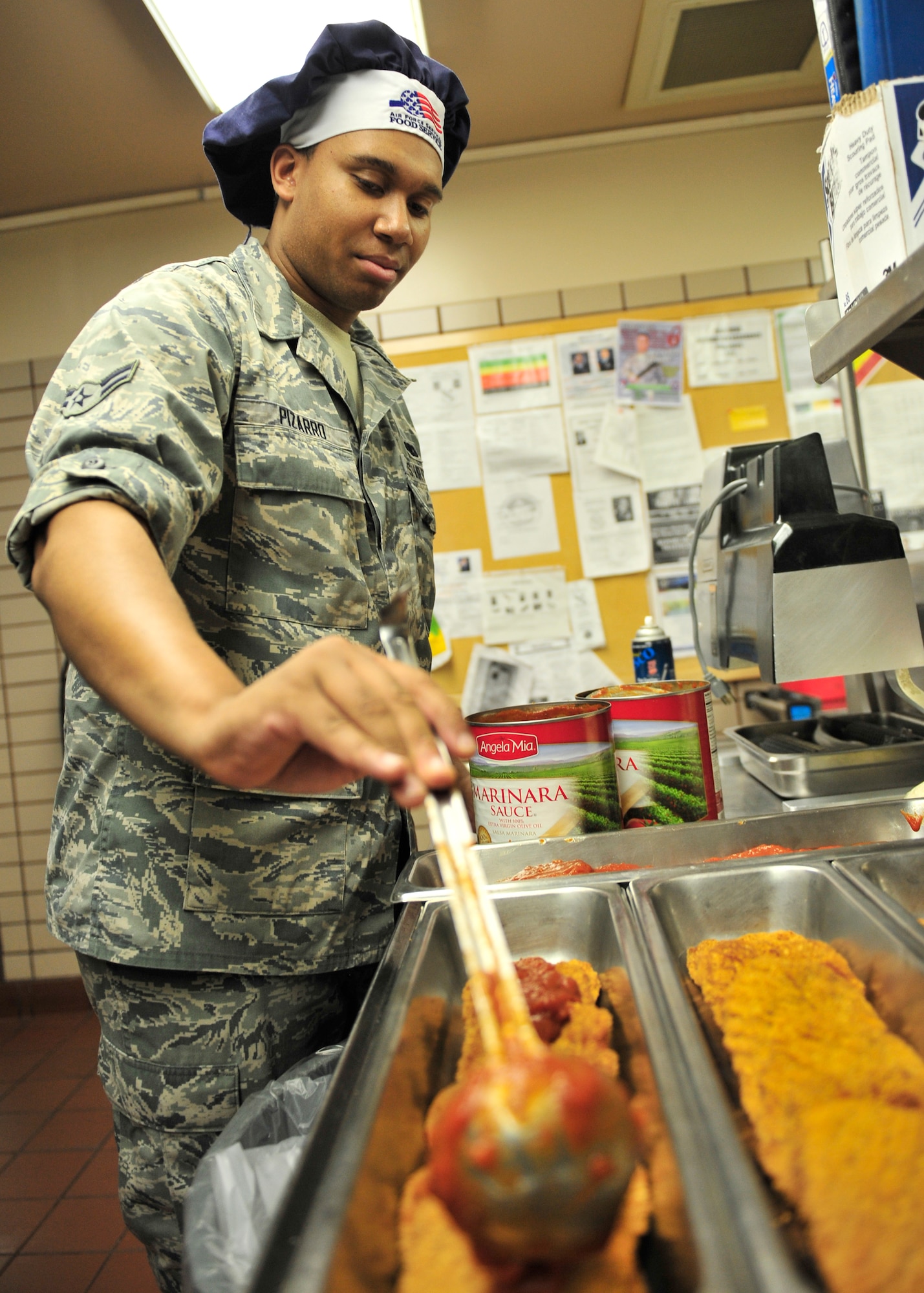 U.S. Air Force Airman 1st Class Tavon Pizarro, 354th Force Support Squadron shift worker, prepares veal parmesan prior to the lunch rush at the Two Seasons Dining Facility during RED FLAG-Alaska 14-2 June 23, 2014, Eielson Air Force Base, Alaska. Since the start of RF-A 14-2, the DFAC cooks over six times more meals than normal, with about 5,300 people served daily. (U.S. Air Force photo by Senior Airman Ashley Nicole Taylor/Released)