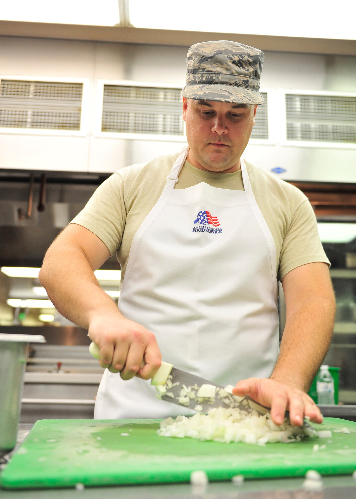 U.S. Air Force Staff Sgt. Christopher Hancock, 125th Force Support Squadron shift supervisor, Florida Air National Guard, Jacksonville, Fla., chops onions in preparation for lunch at the Two Seasons Dining Facility during RED FLAG-Alaska 14-2 June 20, 2014, Eielson Air Force Base, Alaska. Due to the increased operations tempo, augmentees from other units assist shift workers to get the food out on time. (U.S. Air Force photo by Senior Airman Ashley Nicole Taylor/Released)