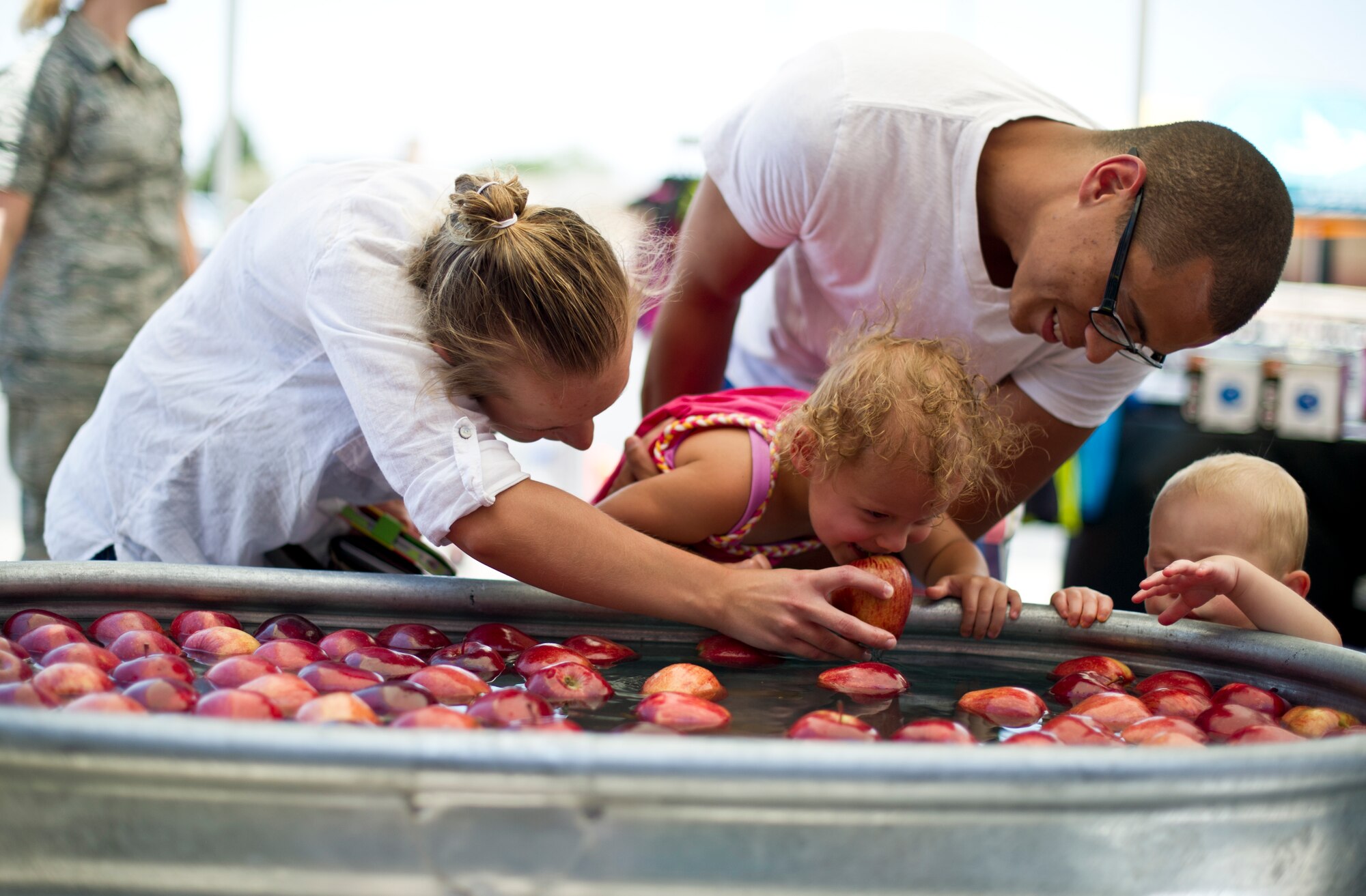 The Cox family bobs for apples at Holloman Air Force Base N.M., June 26, 2014 during a commissary-hosted event to promote healthy living.  Events for the day included education and outreach to the community to improve healthy lifestyle habits, tips for physical fitness and well-being, as well as games. (U.S. Air Force photo by Staff Sgt Stacy Moless/Released))