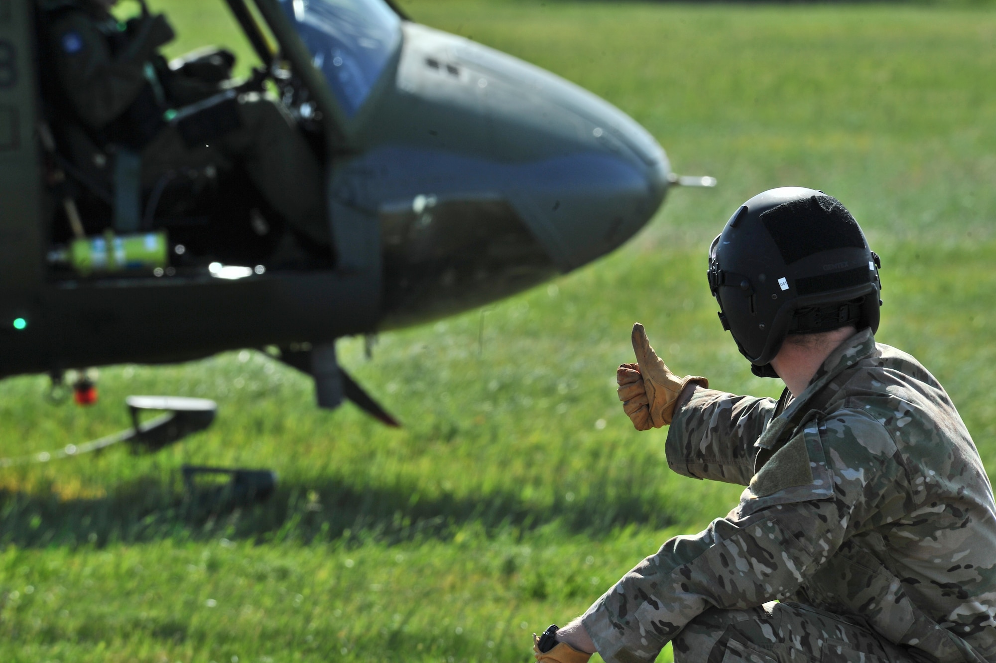 Airman 1st Class Matthew Doyle gives the “ok” to pilots in a UH-1N Iroquois helicopter during hoist training at Fairchild Air Force Base, Washington, June 25, 2014.  Doyle is a Survival, Evasion, Resistance and Escape specialist who instructs a portion of the SV-80B course that gives students an opportunity to experience firsthand how to safely be hoisted into a helicopter. (U.S. Air Force photo by Staff Sgt. Alexandre Montes/Released)