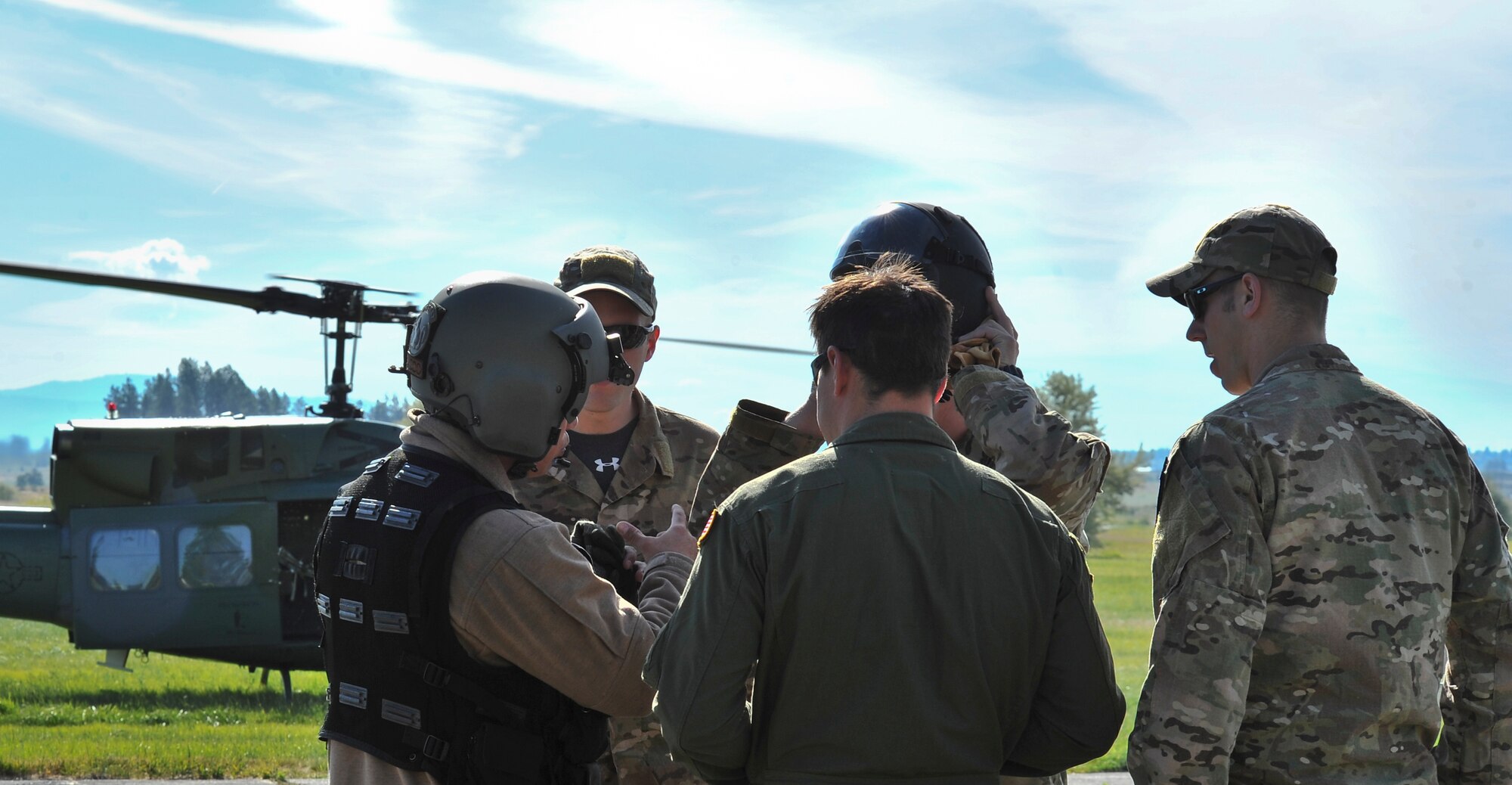 Students from the Survival, Evasion, Resistance and Escape School are given safety instructions on how to approach the UH-1N Iroquois helicopter during hoist training at Fairchild Air Force Base, Washington, June 25, 2014. The SV-80B course gives students an opportunity to experience firsthand how to safely be hoisted into a helicopter. (U.S. Air Force photo by Staff Sgt. Alexandre Montes/Released)