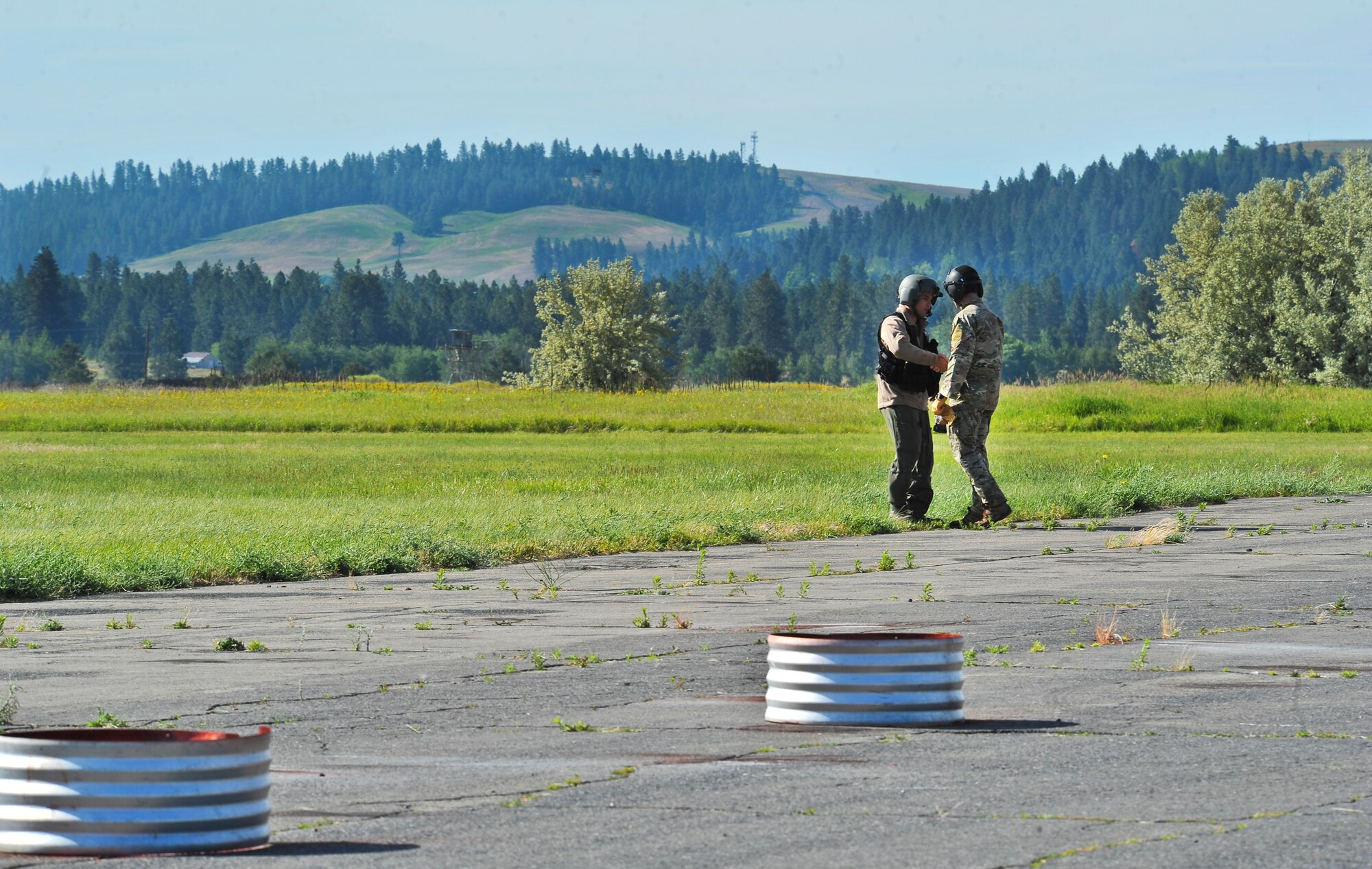 Students from the Survival, Evasion, Resistance and Escape School are given safety instructions on how to approach a UH-1N Iroquois helicopter during hoist training at Fairchild Air Force Base, Washington, June 25, 2014.  The SV-80B course gives students an opportunity to experience firsthand how to safely be hoisted into a helicopter. (U.S. Air Force photo by Staff Sgt. Alexandre Montes/Released)