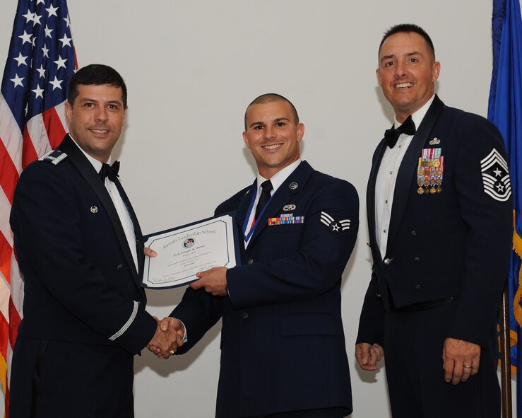 Senior Airman Joseph Remy, 2nd Maintenance Squadron, receives an Airman Leadership School graduation certificate from Col. Andrew Gebara, 2nd Bomb Wing commander, during the ALS Class 14-5 Graduation on Barksdale Air Force Base, La., June 19, 2014. (U.S. Air Force photo/Senior Airman Benjamin Gonsier)