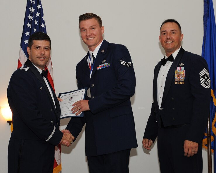 Senior Airman Alexander Palmer, 2nd Munitions Squadron, receives an Airman Leadership School graduation certificate from Col. Andrew Gebara, 2nd Bomb Wing commander, during the ALS Class 14-5 Graduation on Barksdale Air Force Base, La., June 19, 2014. (U.S. Air Force photo/Senior Airman Benjamin Gonsier)