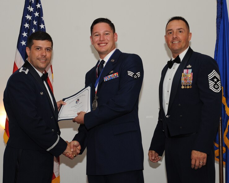 Senior Airman Dillon Dunbar, 2nd Maintenance Squadron, receives an Airman Leadership School graduation certificate from Col. Andrew Gebara, 2nd Bomb Wing commander, during the ALS Class 14-5 Graduation on Barksdale Air Force Base, La., June 19, 2014. (U.S. Air Force photo/Senior Airman Benjamin Gonsier)