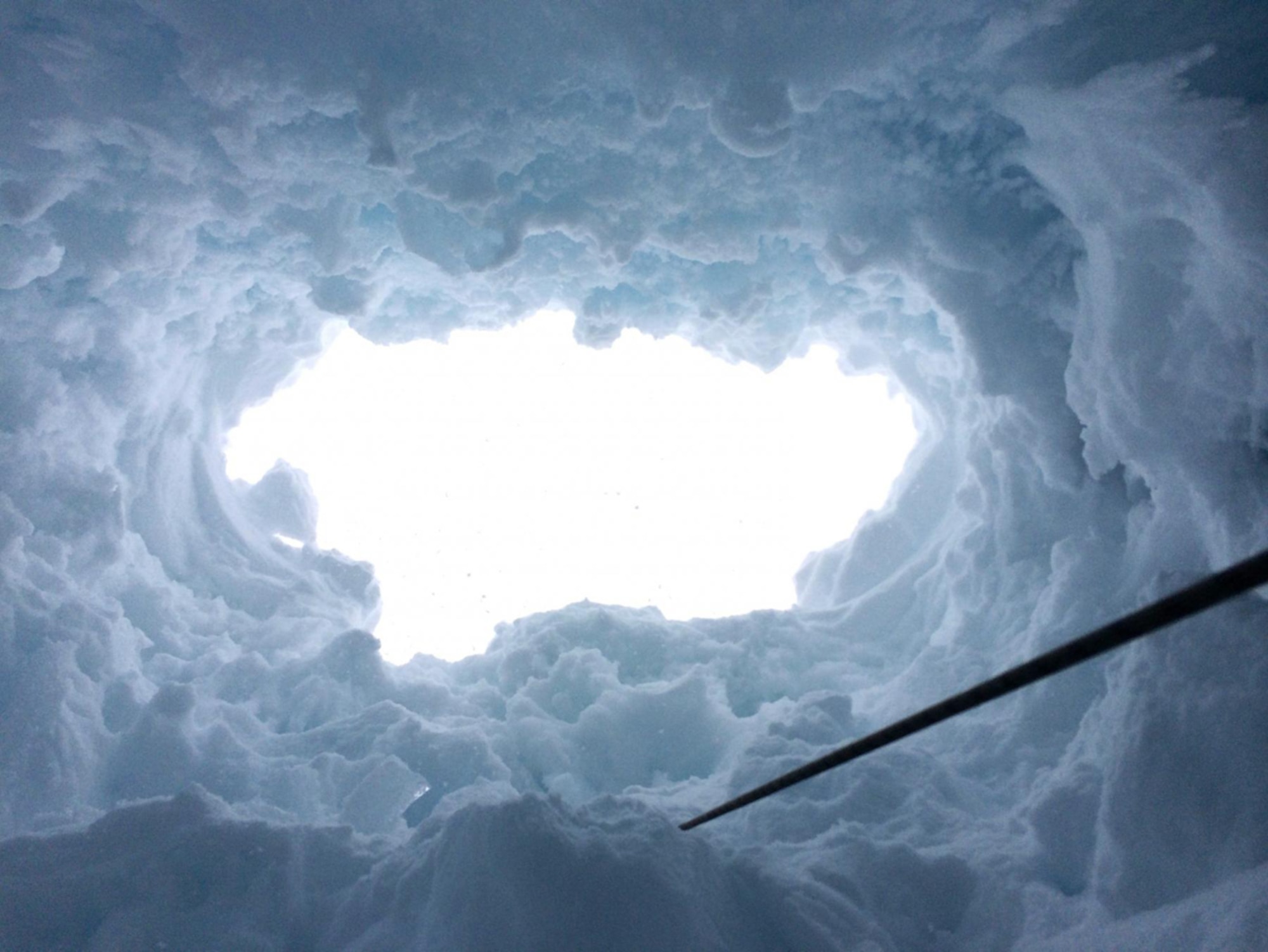 A look up from a hole created by Spc. Tyler Campbell, a paratrooper with the team, when he fell through a snow-bridged crevasse opening while attempting the summit of Mount McKinley. Campbell was saved from an 80-foot fall by the tethered harness he was wearing. (U.S. Army photo/Spc. Tyler Campbell)
