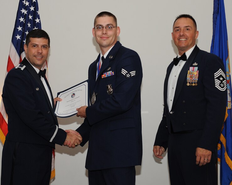 Senior Airman Jeremy Caldwell, 2nd Civil Engineer Squadron, receives an Airman Leadership School graduation certificate from Col. Andrew Gebara, 2nd Bomb Wing commander, during the ALS Class 14-5 Graduation on Barksdale Air Force Base, La., June 19, 2014. (U.S. Air Force photo/Senior Airman Benjamin Gonsier)