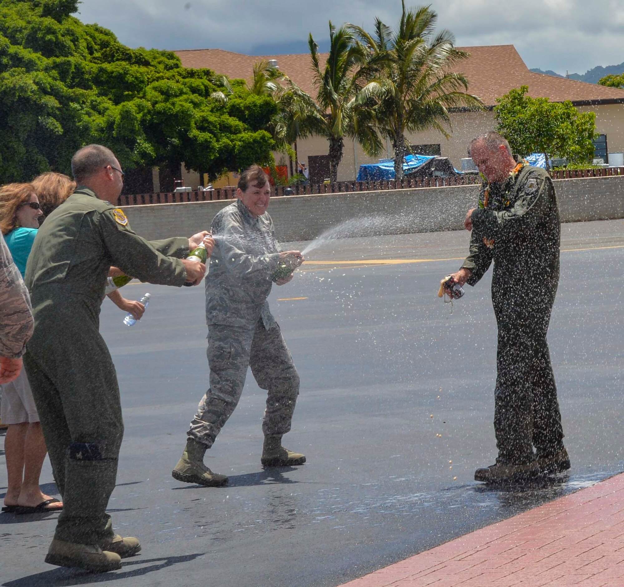 Col. Michael Merritt, 15th Operations Group commander, left, and Col. Virginia Garner, 15th Medical Group commander, center, spray Col. Johnny Roscoe, 15th Wing commander, with sparkling apple cider on the Joint Base Pearl Harbor-Hickam flightline in celebration of his completion of his final training mission June 24, 2014. A pilot’s final flight, or “fini-flight,” is a farewell tradition for Air Force pilots. Roscoe is retiring after 26 years of commissioned service. (U.S. Air Force photo/1st Lt. Andrea Dykes)