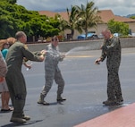 Col. Michael Merritt, 15th Operations Group commander, left, and Col. Virginia Garner, 15th Medical Group commander, center, spray Col. Johnny Roscoe, 15th Wing commander, with sparkling apple cider on the Joint Base Pearl Harbor-Hickam flightline in celebration of his completion of his final training mission June 24, 2014. A pilot’s final flight, or “fini-flight,” is a farewell tradition for Air Force pilots. Roscoe is retiring after 26 years of commissioned service. (U.S. Air Force photo/1st Lt. Andrea Dykes)