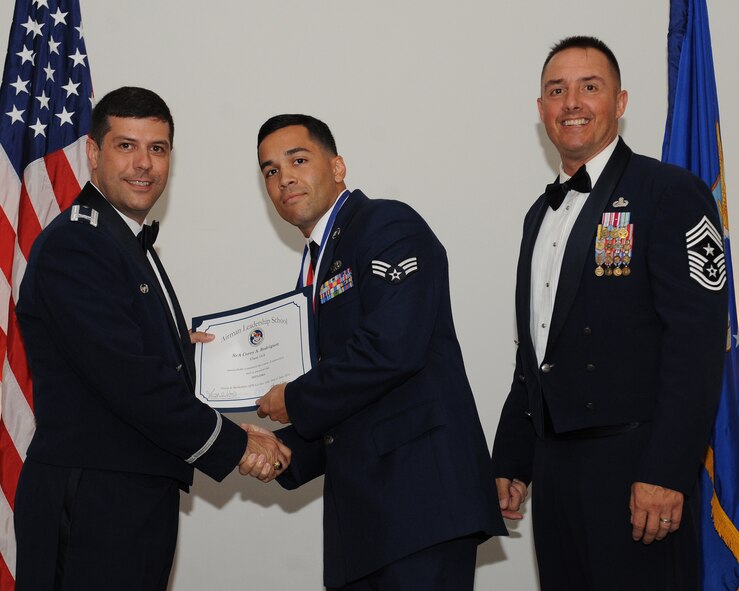 Senior Airman Corey Rodriguez, 2nd Munitions Squadron, receives an Airman Leadership School graduation certificate from Col. Andrew Gebara, 2nd Bomb Wing commander, during the ALS Class 14-5 Graduation on Barksdale Air Force Base, La., June 19, 2014. (U.S. Air Force photo/Senior Airman Benjamin Gonsier)
