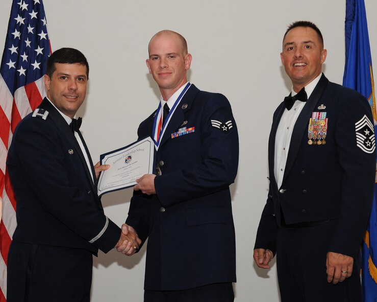 Senior Airman Shawn Layou, 2nd Maintenance Squadron, receives an Airman Leadership School graduation certificate from Col. Andrew Gebara, 2nd Bomb Wing commander, during the ALS Class 14-5 Graduation on Barksdale Air Force Base, La., June 19, 2014. (U.S. Air Force photo/Senior Airman Benjamin Gonsier)
