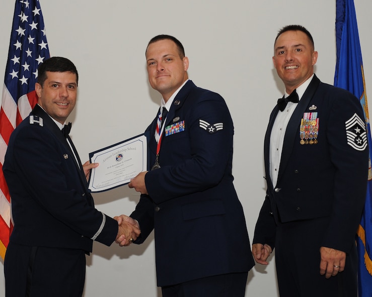 Senior Airman Jonathan Crouch, 2nd Force Support Squadron, receives an Airman Leadership School graduation certificate from Col. Andrew Gebara, 2nd Bomb Wing commander, during the ALS Class 14-5 Graduation on Barksdale Air Force Base, La., June 19, 2014. (U.S. Air Force photo/Senior Airman Benjamin Gonsier)