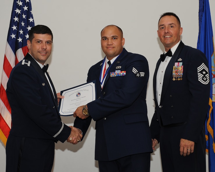 Senior Airman Christopher Santos, 2nd Civil Engineer Squadron, receives an Airman Leadership School graduation certificate from Col. Andrew Gebara, 2nd Bomb Wing commander, during the ALS Class 14-5 Graduation on Barksdale Air Force Base, La., June 19, 2014. (U.S. Air Force photo/Senior Airman Benjamin Gonsier)