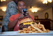 The 2.5-pound monster burger is revealed before the start of a Man vs. Food competition at Moody Air Force Base, Ga., June 25, 2014. U.S. Air Force Senior Airman Arthur Williams, 23d Force Support Squadron food services specialist, organized the competition and cooked the four 2.5-pound burgers by searing them first and then baking them to get them to the correct temperature. (U.S. Air Force photo by Senior Airman Jarrod Grammel/Released)
