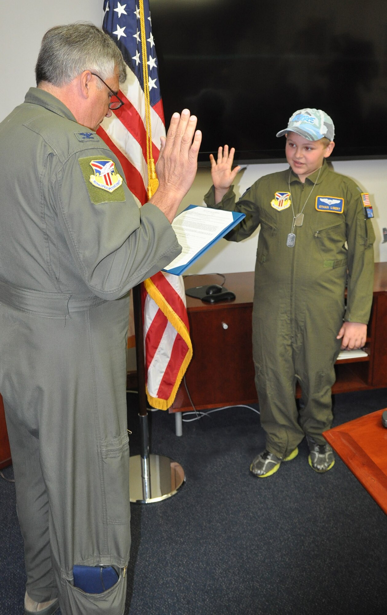 YOUNGSTOWN AIR RESERVE STATION, Ohio -- Air Force Reserve Col. William Phillips, commander of the 910th Operation Group, administers the oath of office swearing in 10-year-old Ethan Libert of Niles, Ohio as an honorary second lieutenant here June 25. Ethan was selected by Akron Children's Hospital Mahoning Valley to be honored as a pilot for a day. He is being treated for Juvenile Diabetes. Ethan was taxied aboard a C-130 Hercules aircraft and given a special tour of the installation. The 910th Airlift Wing pilot for a day program began in 2000 to help bring a ray of sunshine into the lives of children being treated for chronic or life threatening conditions. U.S. Air Force photo by Maj. Brent J. Davis