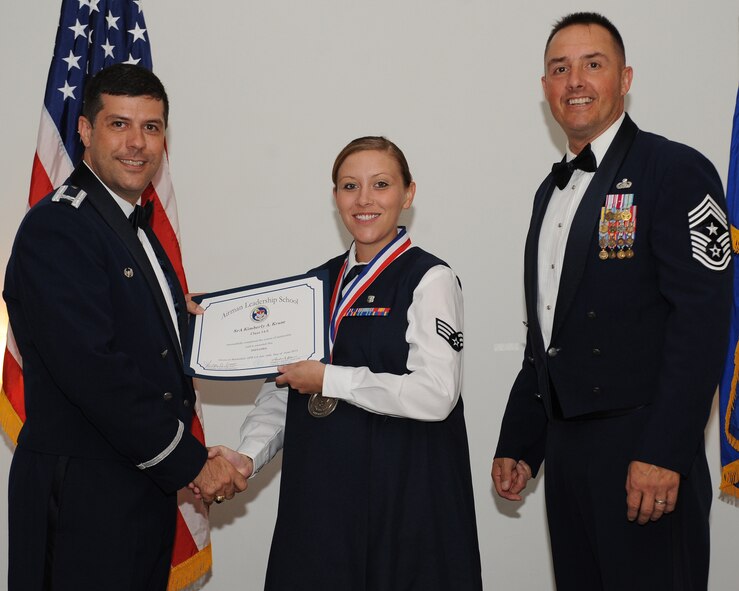 Senior Airman Kimberly Kruse, 2nd Medical Operations Squadron, receives an Airman Leadership School graduation certificate from Col. Andrew Gebara, 2nd Bomb Wing commander, during the ALS Class 14-5 Graduation on Barksdale Air Force Base, La., June 19, 2014. (U.S. Air Force photo/Senior Airman Benjamin Gonsier)