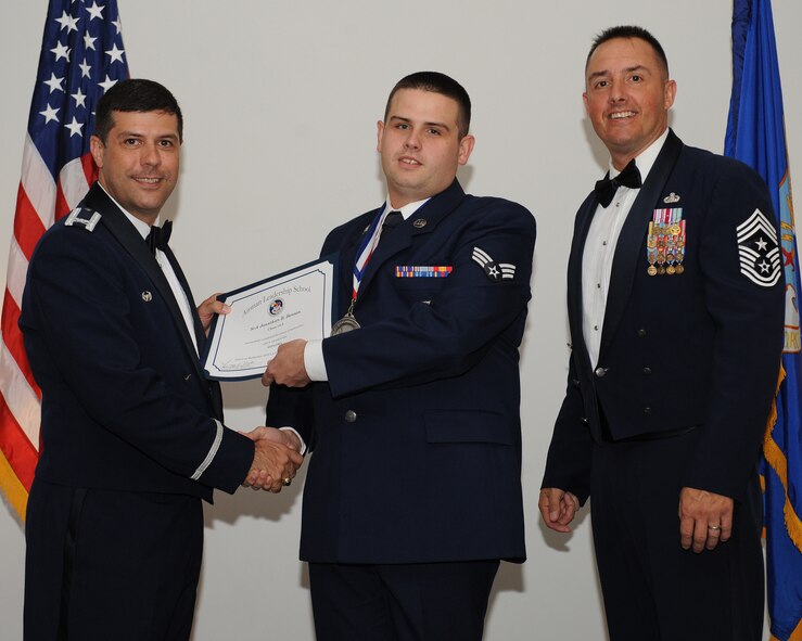 Senior Airman Jonathan Benson, 2nd Munitions Squadron, receives an Airman Leadership School graduation certificate from Col. Andrew Gebara, 2nd Bomb Wing commander, during the ALS Class 14-5 Graduation on Barksdale Air Force Base, La., June 19, 2014. (U.S. Air Force photo/Senior Airman Benjamin Gonsier)