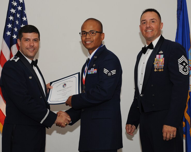 Senior Airman McGarrette Dela Cruz, 2nd Operations Support Squadron, receives an Airman Leadership School graduation certificate from Col. Andrew Gebara, 2nd Bomb Wing commander, during the ALS Class 14-5 Graduation on Barksdale Air Force Base, La., June 19, 2014. (U.S. Air Force photo/Senior Airman Benjamin Gonsier)