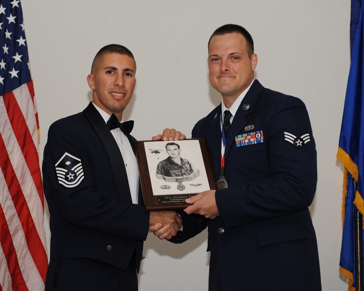 Senior Airman Jonathan Crouch, 2nd Force Support Squadron, receives the Commandant?s Award from Master Sgt. Nader Chebaro, 2nd Munitions Squadron, during the Airman Leadership School Class 14-5 Graduation on Barksdale Air Force Base, La., June 19, 2014. (U.S. Air Force photo/Senior Airman Benjamin Gonsier)