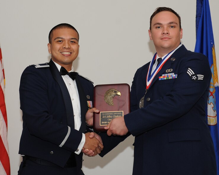 Senior Airman Jeffrey Cleghorn, 2nd Operations Support Squadron, receives the Academic Award from Capt. Janray Calpito, 2nd Force Support Squadron, during the Airman Leadership School Class 14-5 Graduation on Barksdale Air Force Base, La., June 19, 2014. (U.S. Air Force photo/Senior Airman Benjamin Gonsier)