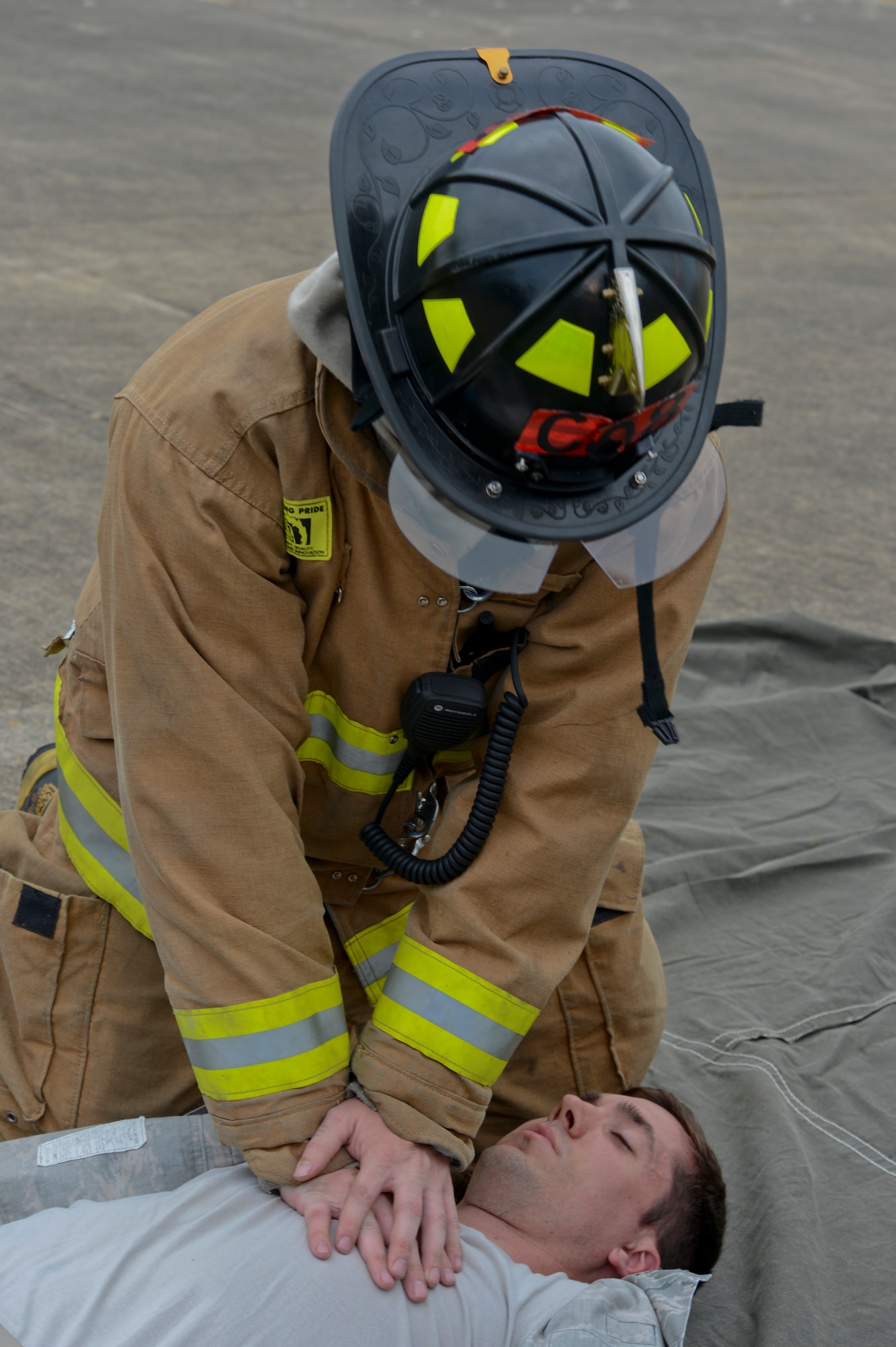A 48th Civil Engineer Squadron firefighter treats a simulated victim during a mission assurance exercise at Royal Air Force Lakenheath, England, June 24, 2014. The three day-long exercise was developed to test readiness and ensure Liberty Airmen and civilians adhere to proper procedures during emergencies or threatening conditions. (U.S. Air Force photo by Airman 1st Class Trevor T. McBride/Released)