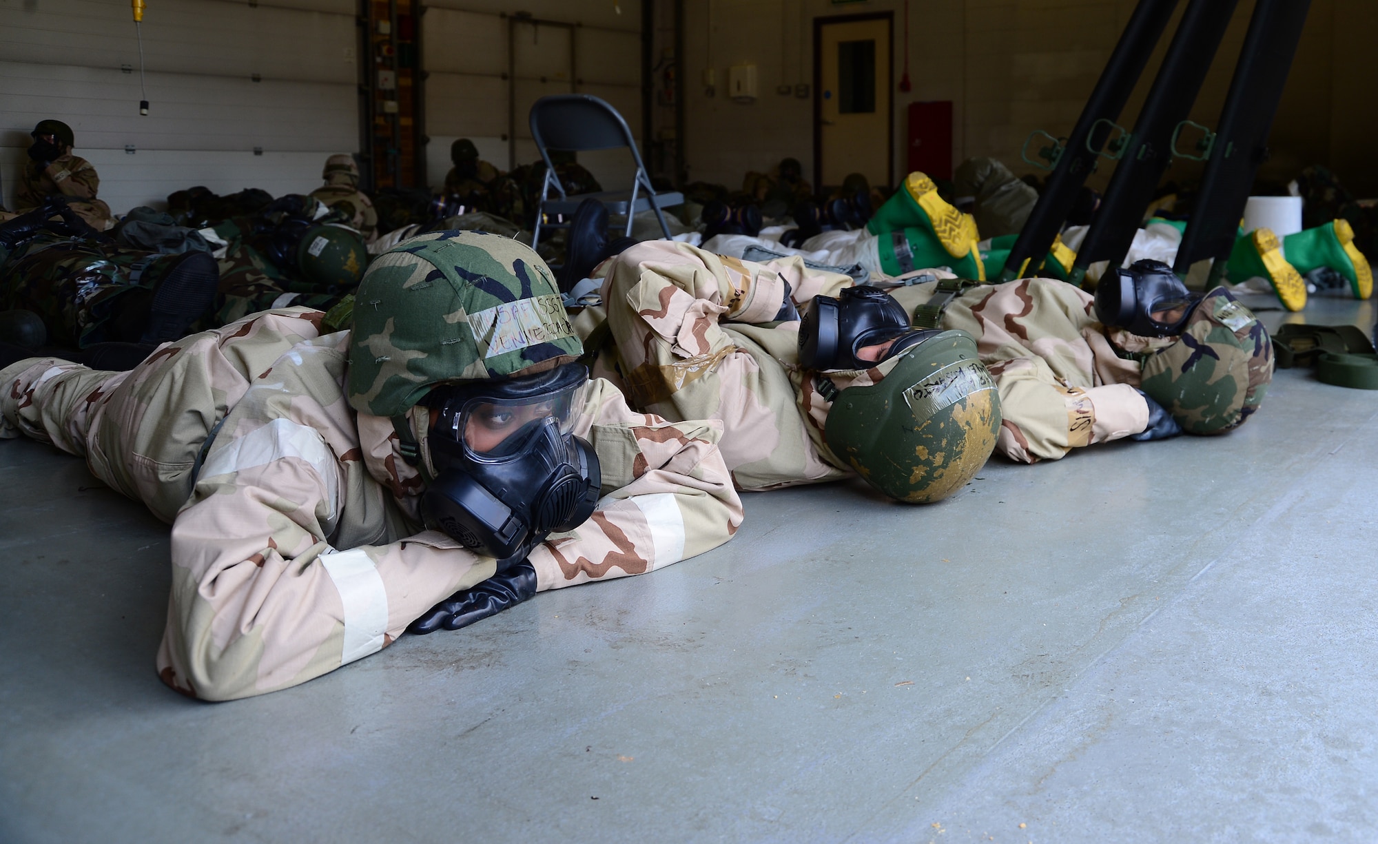 Exercise participants take cover during a simulated attack as part of the 48th Fighter Wing’s mission assurance exercise at Royal Air Force Lakenheath, England, June 25, 2014. The exercise was designed to better prepare Airmen to respond to real-world crises and emergencies while also highlighting the importance of vigilance and safety. (U.S. Air Force photo by Airman 1st Class Dana J. Butler/Released)
