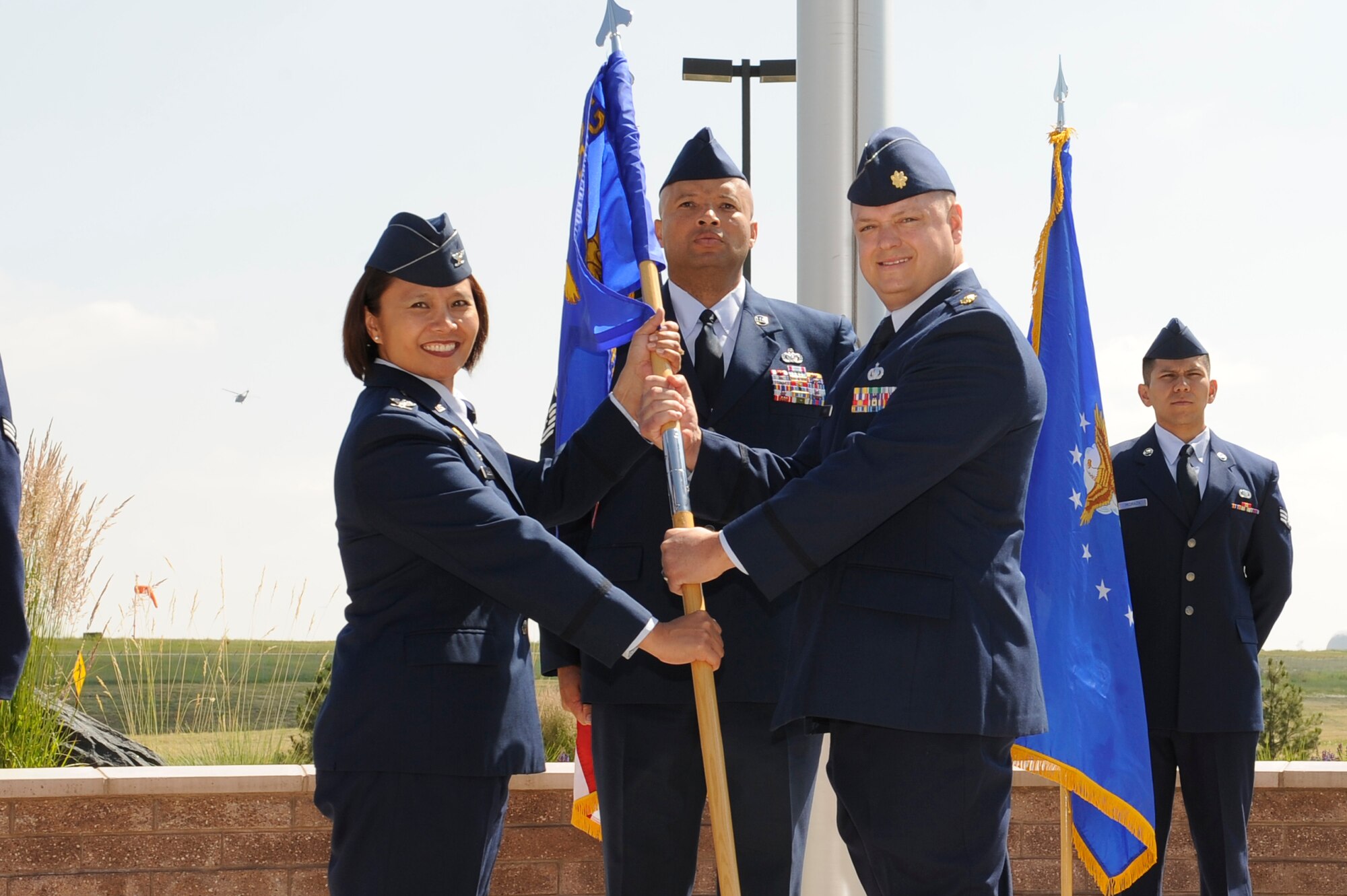 Maj. Gene Smith, 460th Contracting Flight commander receives the 460th Mission Support Group guidon from Col. Rose Jourdan, 460th MSG commander, during the 460th CONF Change of Command Ceremony June 24, 2014, at the 460th Space Wing headquarters building on Buckley Air Force Base, Colo. The event signals Smith's assumption of command from Maj. Jeremy Morrill. (U.S. Air Force photo by Airman 1st Class Samantha Saulsbury/Released)