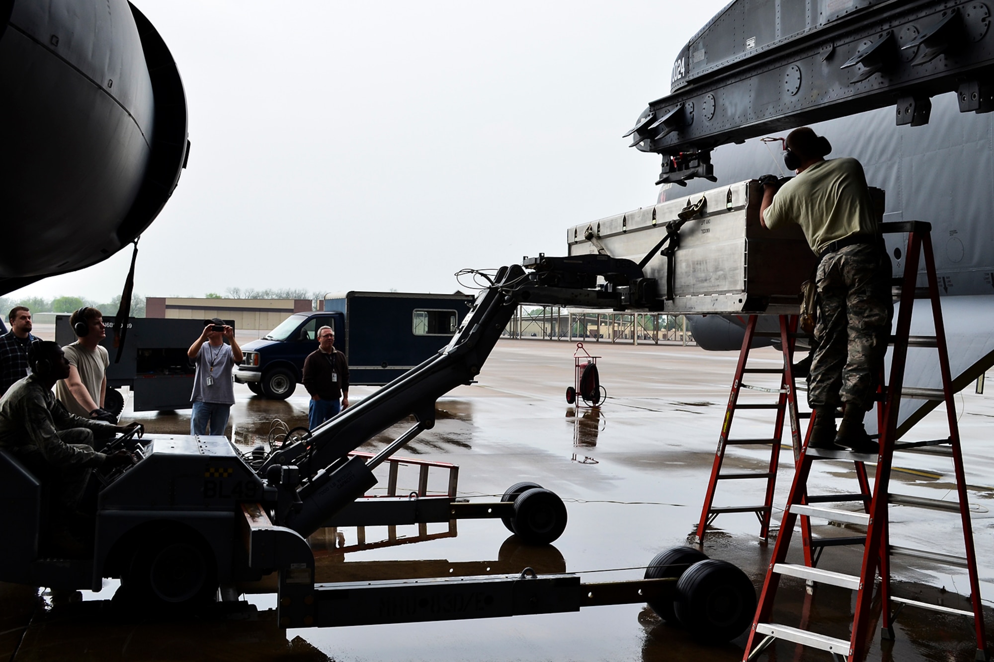 A casket containing the AN/ASQ-236 Radar Pod is lifted to a mounting station on a 93rd Bomb Squadron B-52H Stratofortress, April 14, 2014, Barksdale Air Force Base, Louisiana. This marks the first test of the pod on a B-52, which will give the aircraft the ability to precisely geo-locate points of interest and conduct surveillance activities day or night, in adverse weather conditions. (U.S. Air Force photo by Master Sgt. John Paxton/Released)