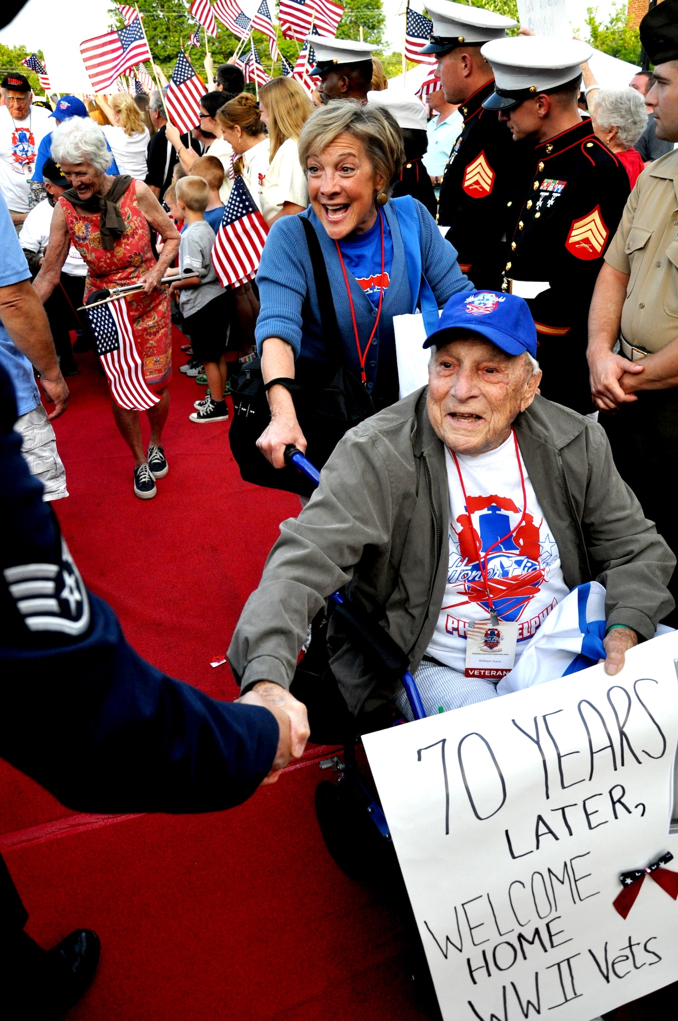 Former Army Air Corps lieutenant, William Davis, shakes the hand of an Air Force staff sergeant as he is escorted down the red carpet during a welcome reception June 21, 2014, at St. Kevin’s Church, Springfield, Pa. Honor Flight Philadelphia escorted more than 150 World War II and Korean War veterans to the nation’s capital and to Arlington National Cemetery, Virginia. Upon their return, they were greeted by more than 700 people, including service members from Joint Base McGuire-Dix-Lakehurst, N.J. (U.S. Air Force photo by 2nd Lt. Carrie Volpe/Released)
