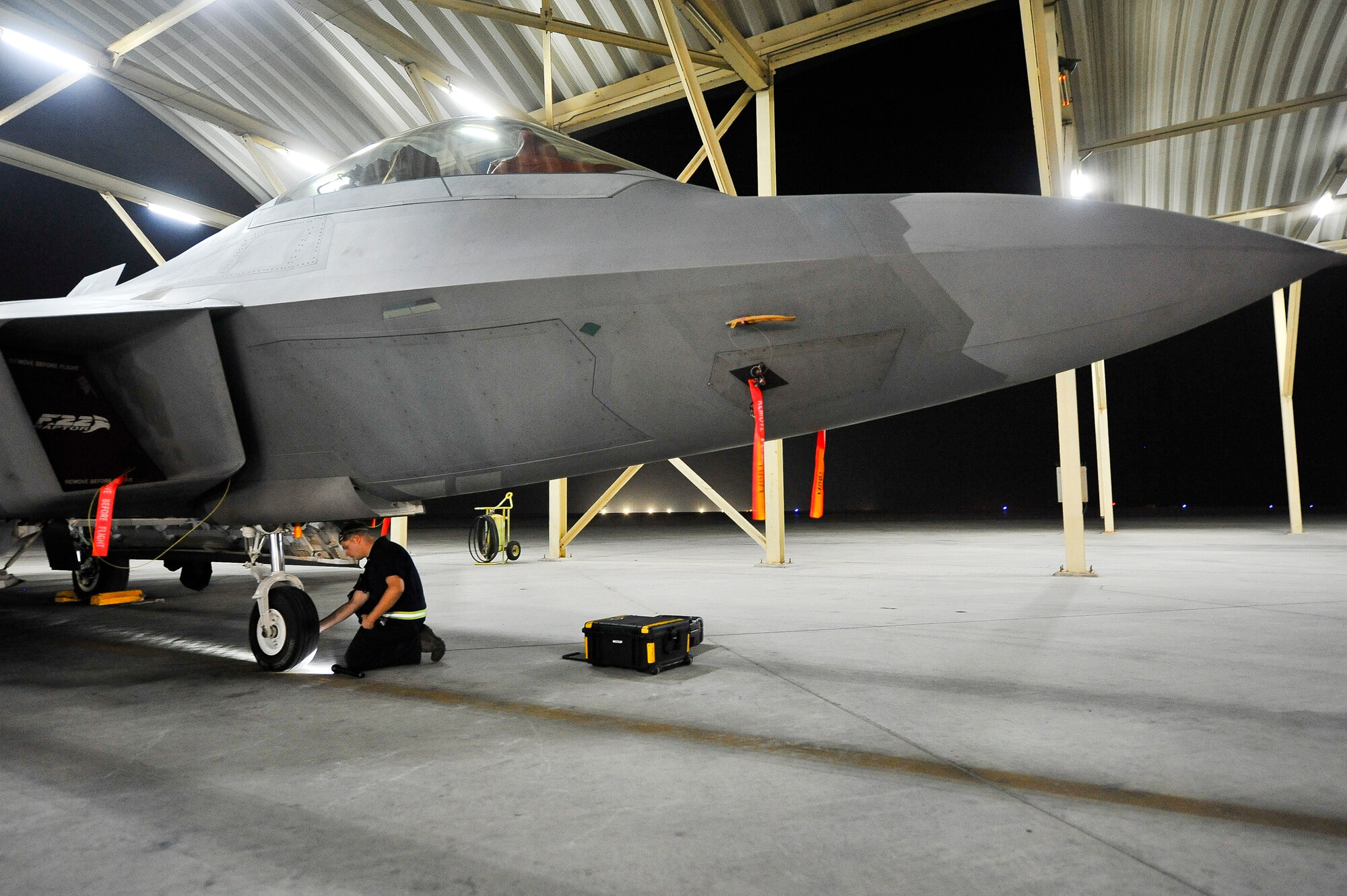 Senior Airman Patrick Mooneyham, an assistant dedicated crew chief deployed from Joint Base Langley-Eustis, Va., checks the tire pressure in an F-22A Raptor June 17, 2014, at an undisclosed location in Southwest Asia. Tire pressure is just one part of pre-flight servicing checks that ensure an aircraft is combat-ready. (U.S. Air Force photo by Tech. Sgt. Russ Scalf/Released)