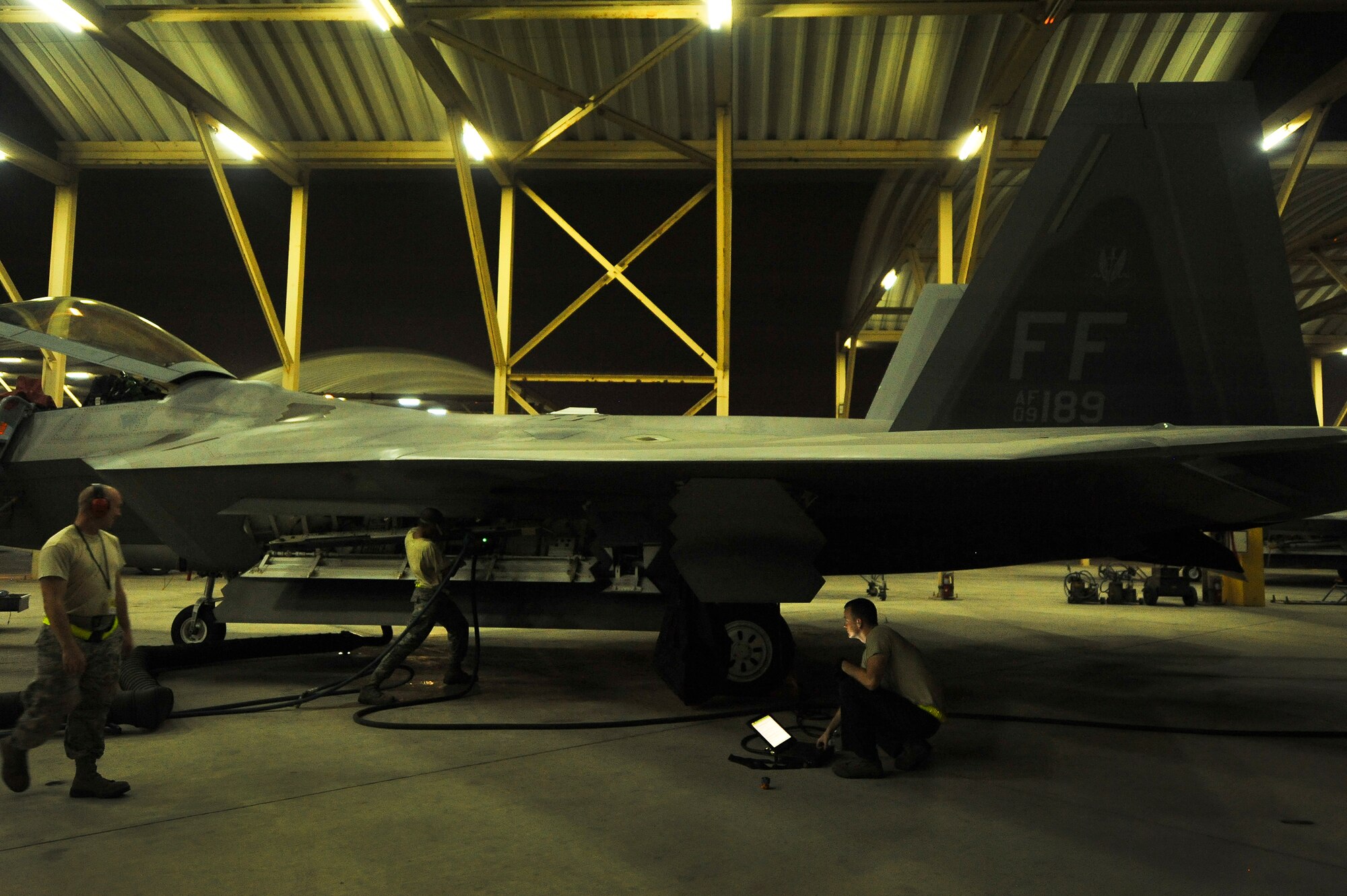 Tech. Sgt. Kristopher Kersten, Senior Airman Steven Hughes and Staff Sgt. Stephen Halbert, all deployed from Joint Base Langley-Eustis, Va., connect a liquid coolant supply hose to an F-22A Raptor June 17, 2014, at an undisclosed location in Southwest Asia. Coolant is required anytime avionics operations checks are performed to prevent equipment from overheating. (U.S. Air Force photo by Tech. Sgt. Russ Scalf/Released)