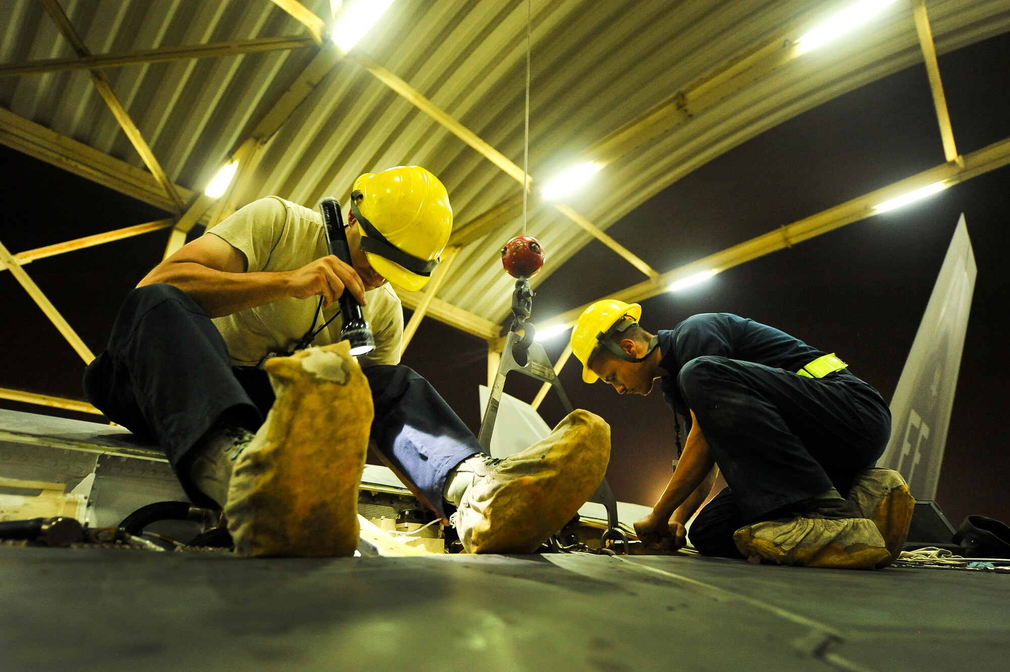Senior Airman John-Anthony Centano and Senior Airman Nicholas Banducci, both deployed from Joint Base Langley-Eustis, Va., install an auxiliary power unit into an F-22A Raptor June 17, 2014, at an undisclosed location in Southwest Asia.  The repair is relatively uncommon and considered heavy maintenance. (U.S. Air Force photo by Tech. Sgt. Russ Scalf/Released)