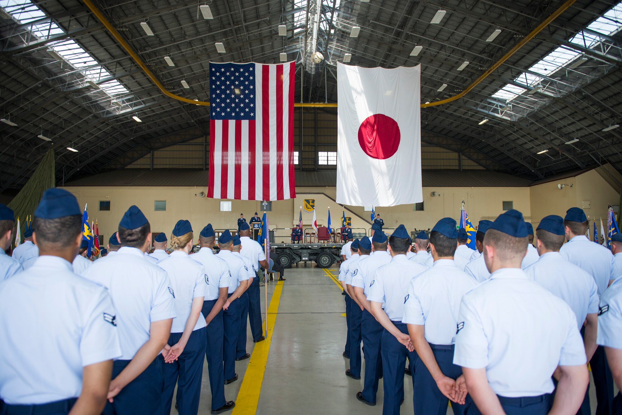 Members from the 374th Airlift Wing stand at parade rest during the 374 AW change of command ceremony at Yokota Air Base, Japan, June 26, 2014. The change of command is a traditional military ceremony in which the departing commander assembles their personnel for presentation to the incoming commander. (U.S. Air Force photo by Staff Sgt. Chad C. Strohmeyer/Released)
