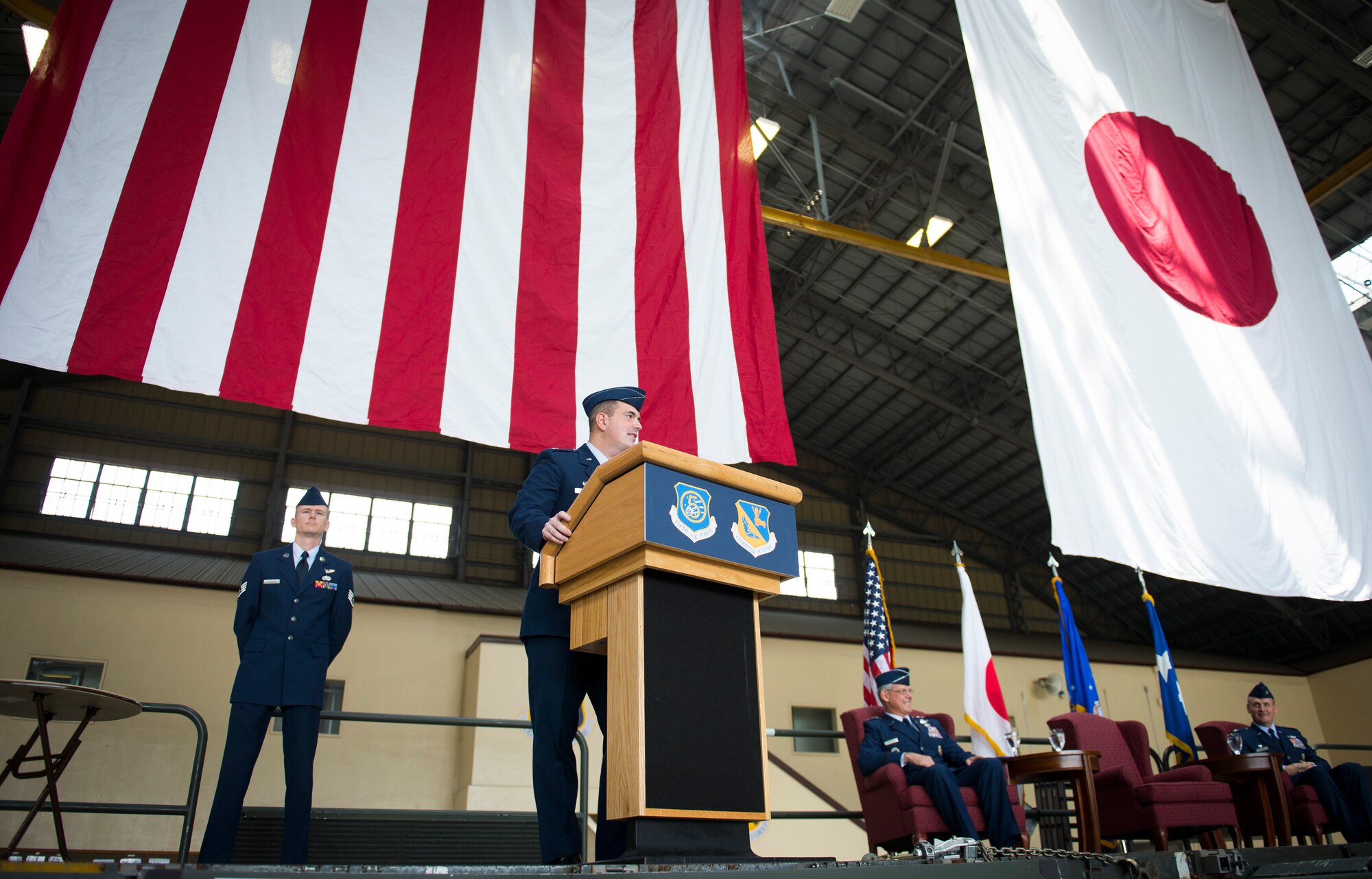 Col. Mark August addresses team Yokota and representatives from the Japanese community prior to relinquishing command during the 374th Airlift Wing change of command ceremony at Yokota Air Base, Japan, June 26, 2014. He spoke of the professionalism and effectiveness he believed the 374 AW represents. (U.S. Air Force photo by Staff Sgt. Chad C. Strohmeyer/Released)