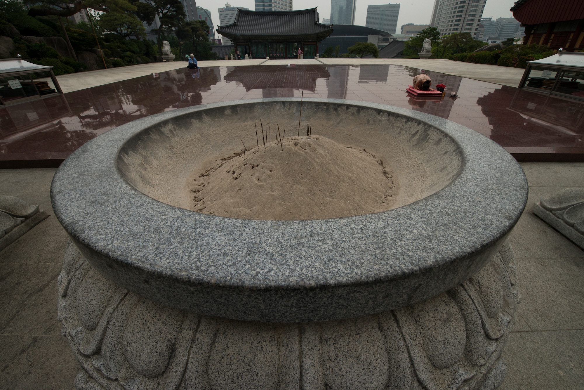 Supplicants pray in front of the Great Buddha statue at Bonguensa Temple May 24, 2014, in Seoul, Republic of Korea. The temple grounds house more than 20 buildlings, a great Buddha statue, a pagoda and a cafeteria and tea shop for visitors. (U.S. Air Force photo by Staff Sgt. Jake Barreiro)