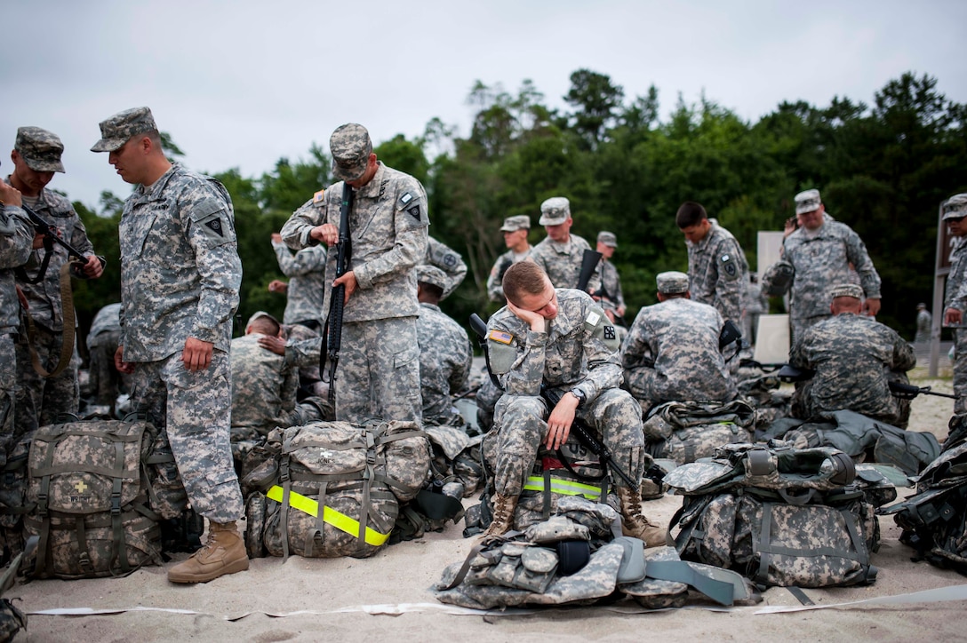 Army Spc. Gregory Doty takes a nap after an 8-mile road march during the 2014 Army Reserve Best Warrior Competition on Joint Base McGuire-Dix-Lakehurst, N.J., June 25, 2014.