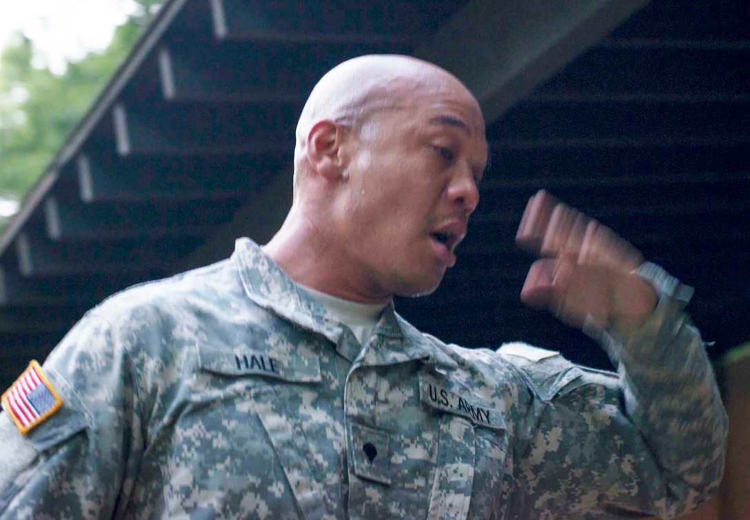 Army Spc. Stanley Hale Jr. waves his arms to dissipate tear gas after ...