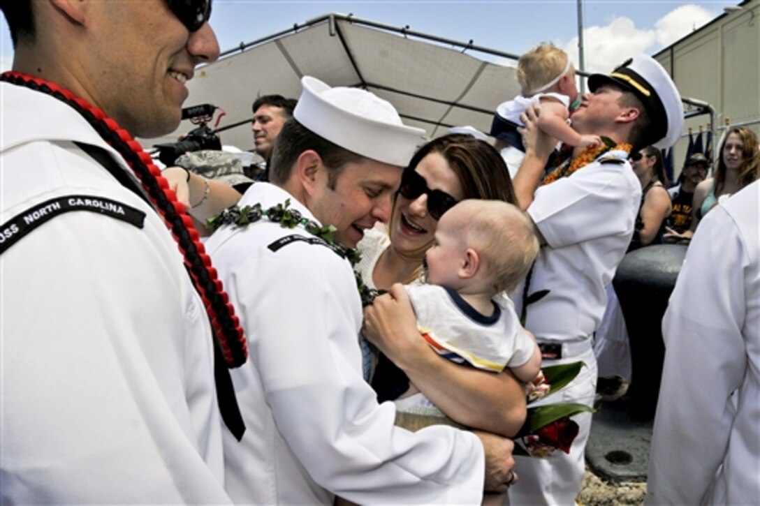 Navy Petty Officer 1st Class Mike Allred reunites with his family on the pier following the return of the attack submarine USS North Carolina to Joint Base Pearl Harbor-Hickam in Honolulu, June 19, 2014, after completing a deployment to the western Pacific region. The North Carolina conducted operations and theater security exercises to contribute to the nation's strategic posture in the region. Allred is an electronics technician. 
