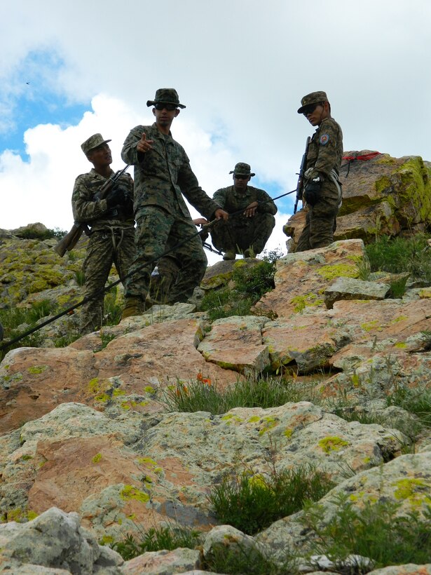 U.S. Marine Corps Staff Sgt. Gale L. Anders and Sgt. Gustavo A. Pesquera instruct members of the Mongolian Armed Forces in the proper techniques for hasty rappelling down steep rock ledges June 21 as part of the Survivor’s Course portion of Exercise Khaan Quest 2014 at the Five Hills Training Area, Mongolia. Khaan Quest is a regularly scheduled, multinational exercise co-sponsored this year by U.S. Army Pacific, and hosted annually by Mongolian Armed Forces. KQ14 is the latest in a continuing series of exercises designed to promote regional peace and security. This year marks the 12th iteration of this training event. Anders is the operations chief for 3rd Marine Division, III Marine Expeditionary Force. Pesquera is an instructor section leader at the Jungle Warfare Training Center at Camp Gonsalves, Okinawa, Japan.