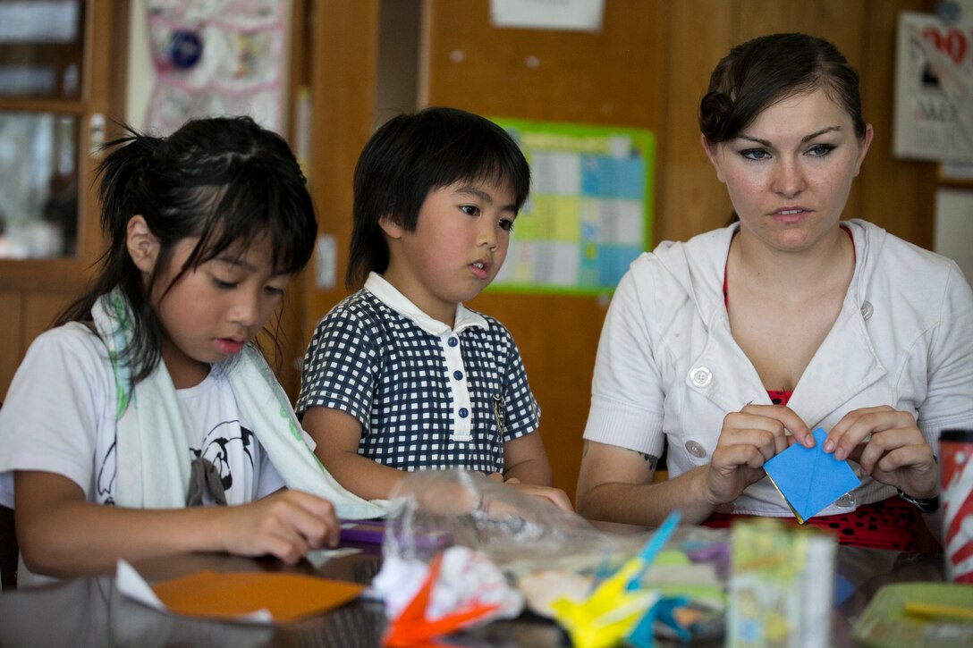 Sgt. Kiera Persen, right, folds origami with children of the Nagomi Nursing Home for Children June 22 in Nago. Marines and sailors spent the day doing activities and having an American-style cookout with the residents. Persen is an Appleton, Wisconsin, native and combat engineer with Combat Logistics Battalion 31, 31st Marine Expeditionary Unit, III Marine Expeditionary Force. (U.S. Marine Corps photo by Lance Cpl. Brittany A. James/Released)