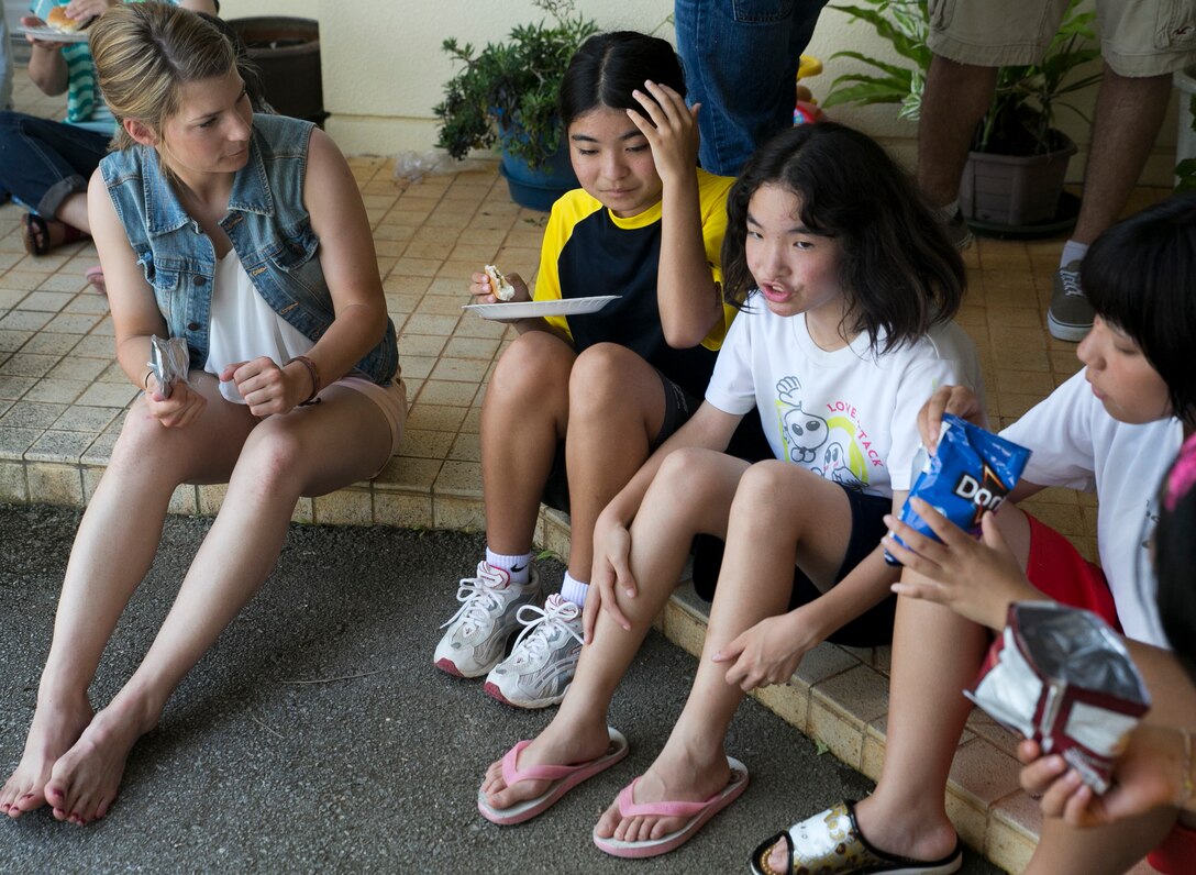 Lance Cpl. Amelia Williams, left, enjoys a cookout with the children of the Nagomi Nursing Home for Children June 22 in Nago. The children experienced American culture through interaction with the Marines. Williams is a Bremerton, Washington, native and a radio operator with 3rd Marine Logistics Group currently assigned to Combat Logistics Battalion 31, 31st Marine Expeditionary Unit, III Marine Expeditionary Force.  (U.S. Marine Corps photo by Lance Cpl. Brittany A. James/Released)