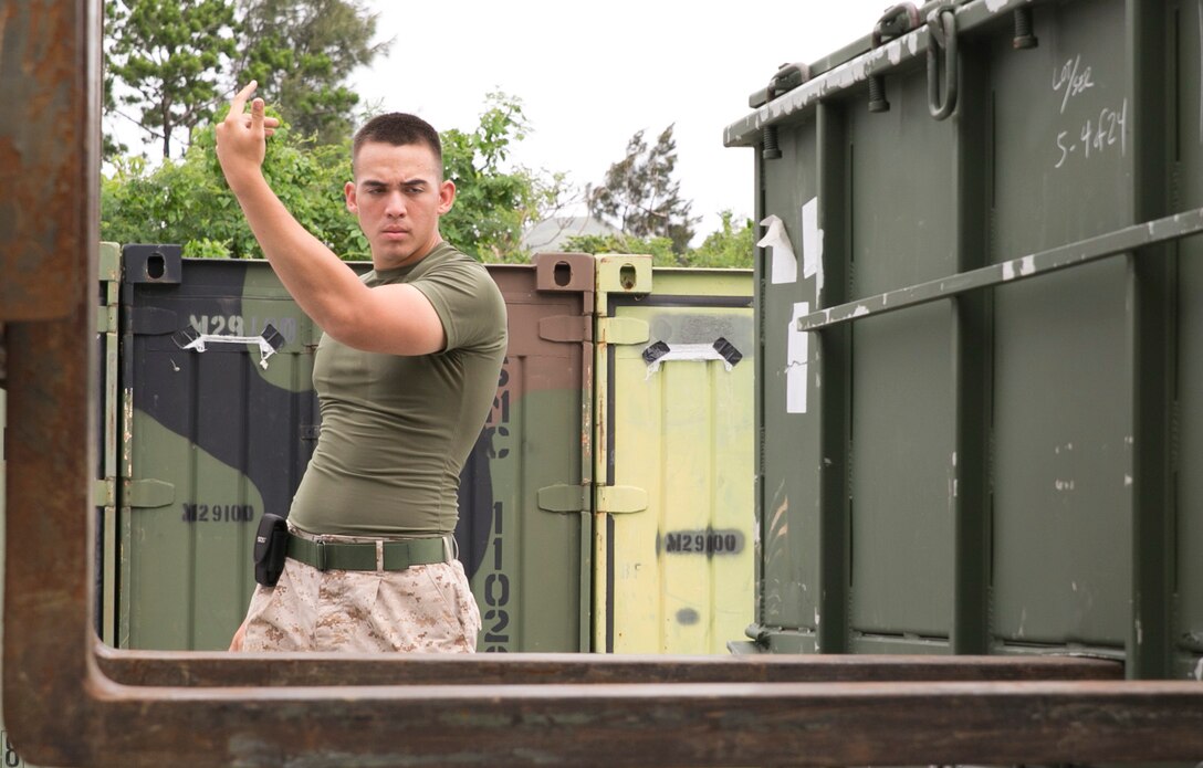Lance Cpl. Brandon Meth ensures that the operator of a Tractor, Rubber-Tired, Articulated Steering, Multi-Purpose Forklift connects with a container June 18 during a mobility exercise at Camp Hansen. This was part of an exercise to test the Marines on their response time in case they are needed for a deployment. Meth is a San Antonio, Texas, native and engineer equipment operator with Bulk Fuel Company, 9th Engineer Support Battalion, 3rd Marine Logistics Group, III Marine Expeditionary Force.