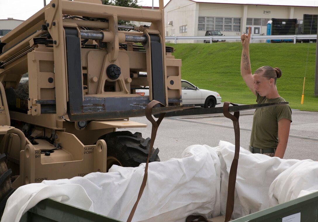 Lance Cpl. Amber D. Terry guides the operator of a Light Capacity Rough Terrain Forklift during a mobility exercise June 18 at Camp Hansen. This was part of an exercise to test the Marines on their response time in case they are needed for a deployment. Terry is a Locust Grove, Georgia, native and bulk fuel specialist with Bulk Fuel Company, 9th Engineer Support Battalion, 3rd Marine Logistics Group, III Marine Expeditionary Force. 