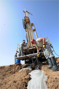 Army Spc. Todd Glandden, 257th Engineer Team member, shovels foam away from the bore hole of the well site as cuttings shoot out of the bore hole during 24-hour well drilling operations just outside Camp Lemonnier here, March 12, 2012. This project allowed the team to evaluate the water tables in the aquifer and make plans for camp expansion. The well development project directly supports Camp Lemonnier's initiative to identify alternative well locations and assist in development of camp infrastructure.