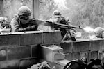 Canadian Cpl Anthony Van Wyngaarden, a machine gunner with 31st Canadian Brigade Group, Land Forces Central, Ontario, lays heavy suppressive fire for his fellow soldiers as they enter a building to search for simulated enemies during exercise Arrowhead Lightning 2012 at Muscatatuck Urban Training Center March 16, 2012.