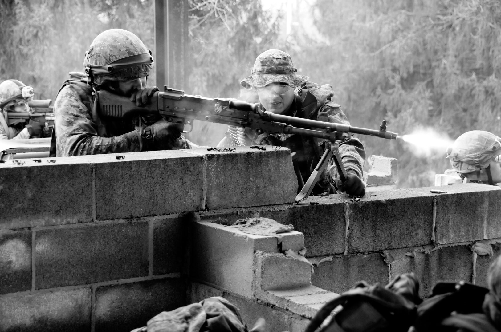 Canadian Cpl Anthony Van Wyngaarden, a machine gunner with 31st Canadian Brigade Group, Land Forces Central, Ontario, lays heavy suppressive fire for his fellow soldiers as they enter a building to search for simulated enemies during exercise Arrowhead Lightning 2012 at Muscatatuck Urban Training Center March 16, 2012.