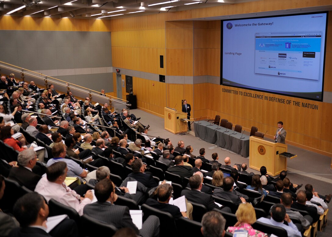 Zacharie Hall, from the Intelligence Systems Support Office, and DIA’s Dan Doney demonstrate the new Open Innovation Gateway for industry partners at DIA’s second annual Innovation Symposium June 25. 