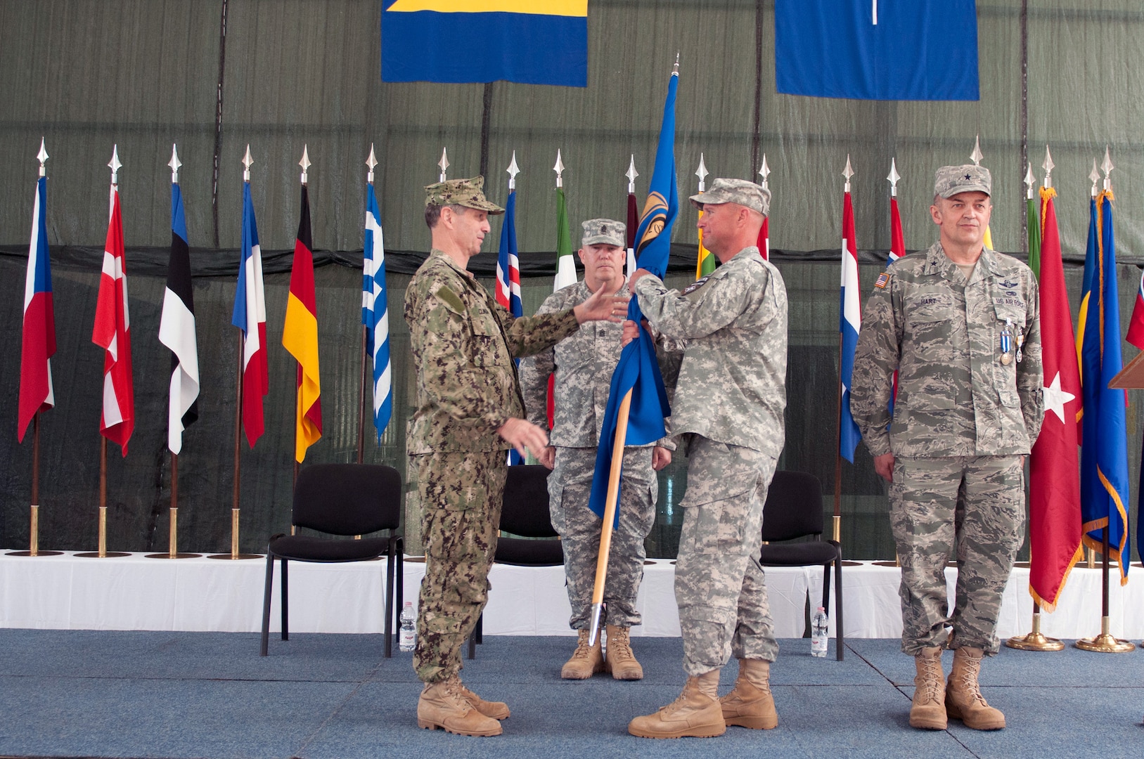 Navy Adm. Bruce W. Clingan, commander Allied Joint Force Command Naples, commander U.S. Naval Forces Europe, commander U.S. Naval Forces Africa, passes the North Atlantic Treaty Organization colors to Army Brig. Gen. Christopher J. Petty, a Colorado National Guard member, during a transfer of authority ceremony at Camp Butmir, Bosnia, June 25, 2014. Petty took over command from Air Force Brig. Gen. Merle D. Hart, an Air Force Reservist and outgoing commander of NATO Headquarters Sarajevo.