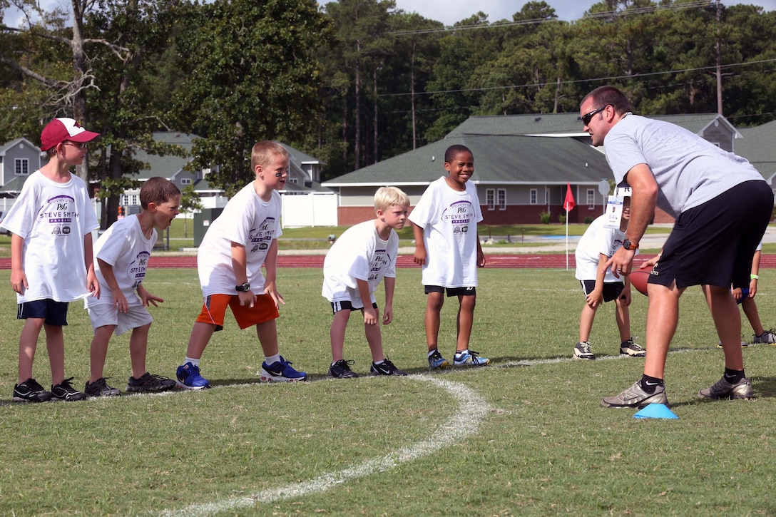 Andrew Gurley teaches a group of campers the proper linebacker stance during the Steve Smith ProCamp at Marine Corps Air Station Cherry Point, N.C., June 24, 2014. The installation was selected to host the camp for the second time after winning a contest between commissaries throughout the country. Gurley is a offensive-line coach at Croatan High School.
